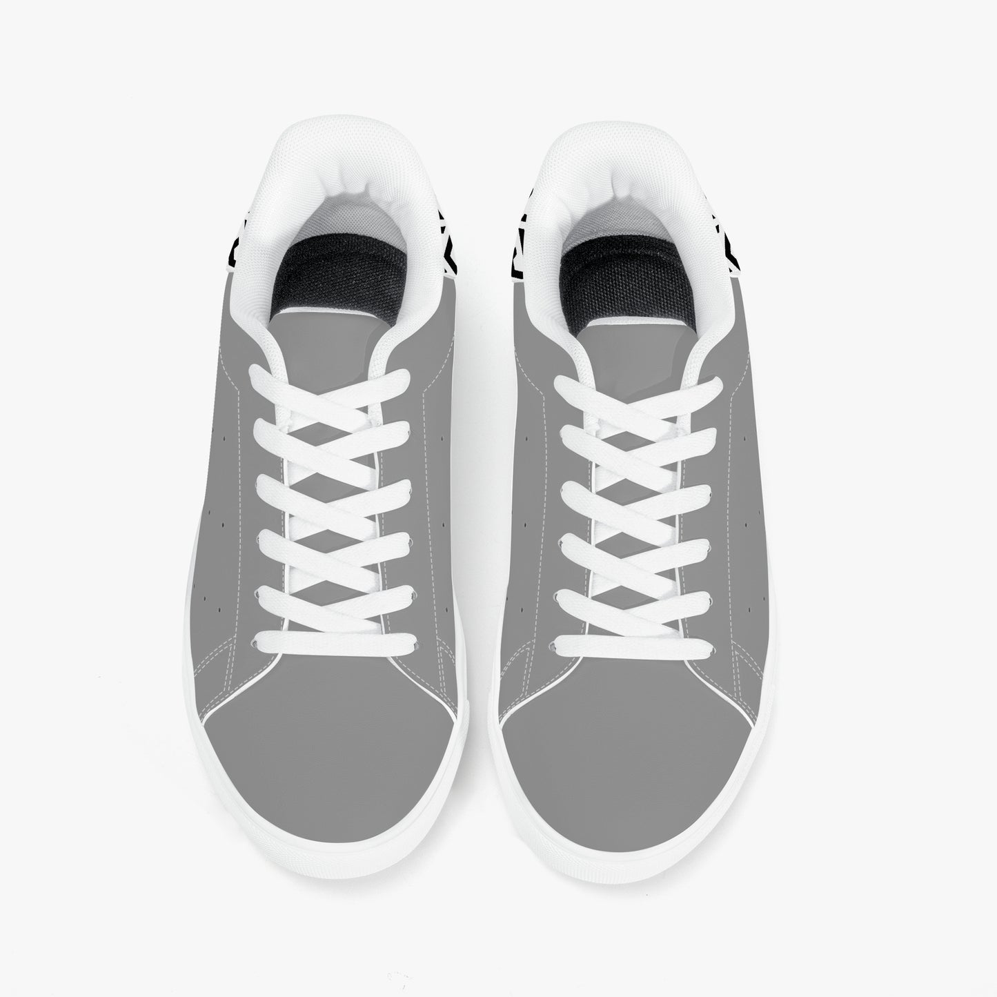 Gray sneakers with white laces on a light gray background