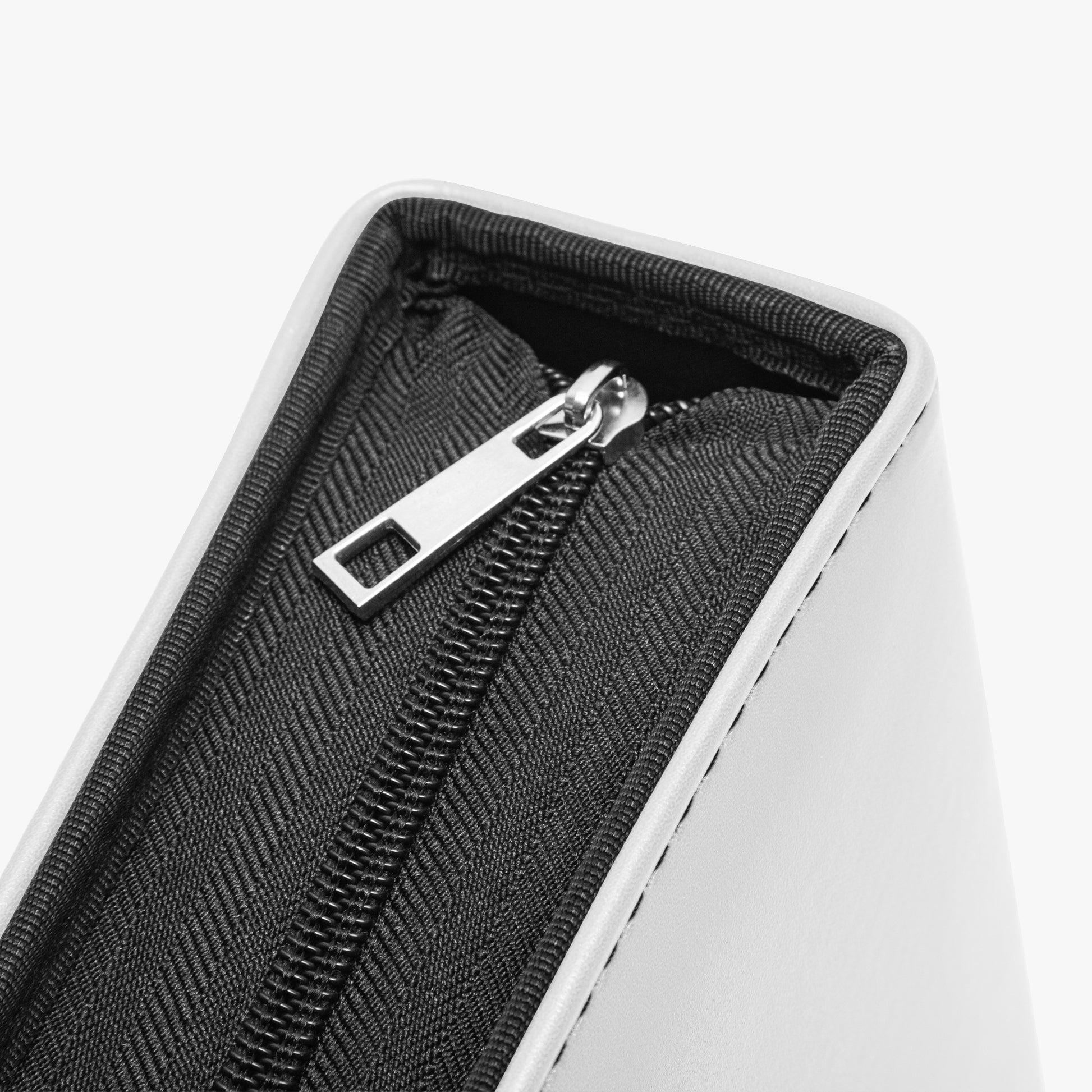 Close-up of a black textured pouch with a silver zipper on a white background