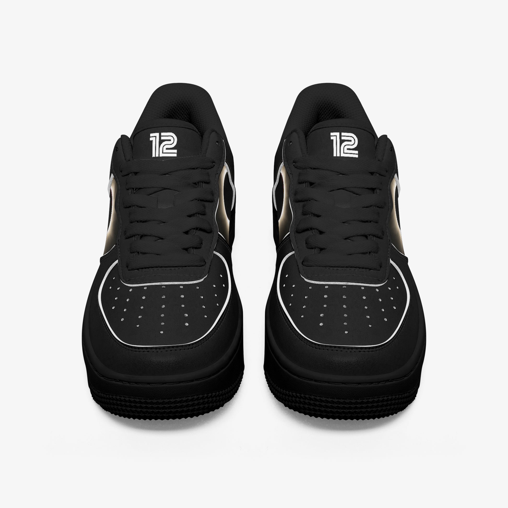 Black sneakers with white accents on a light gray background