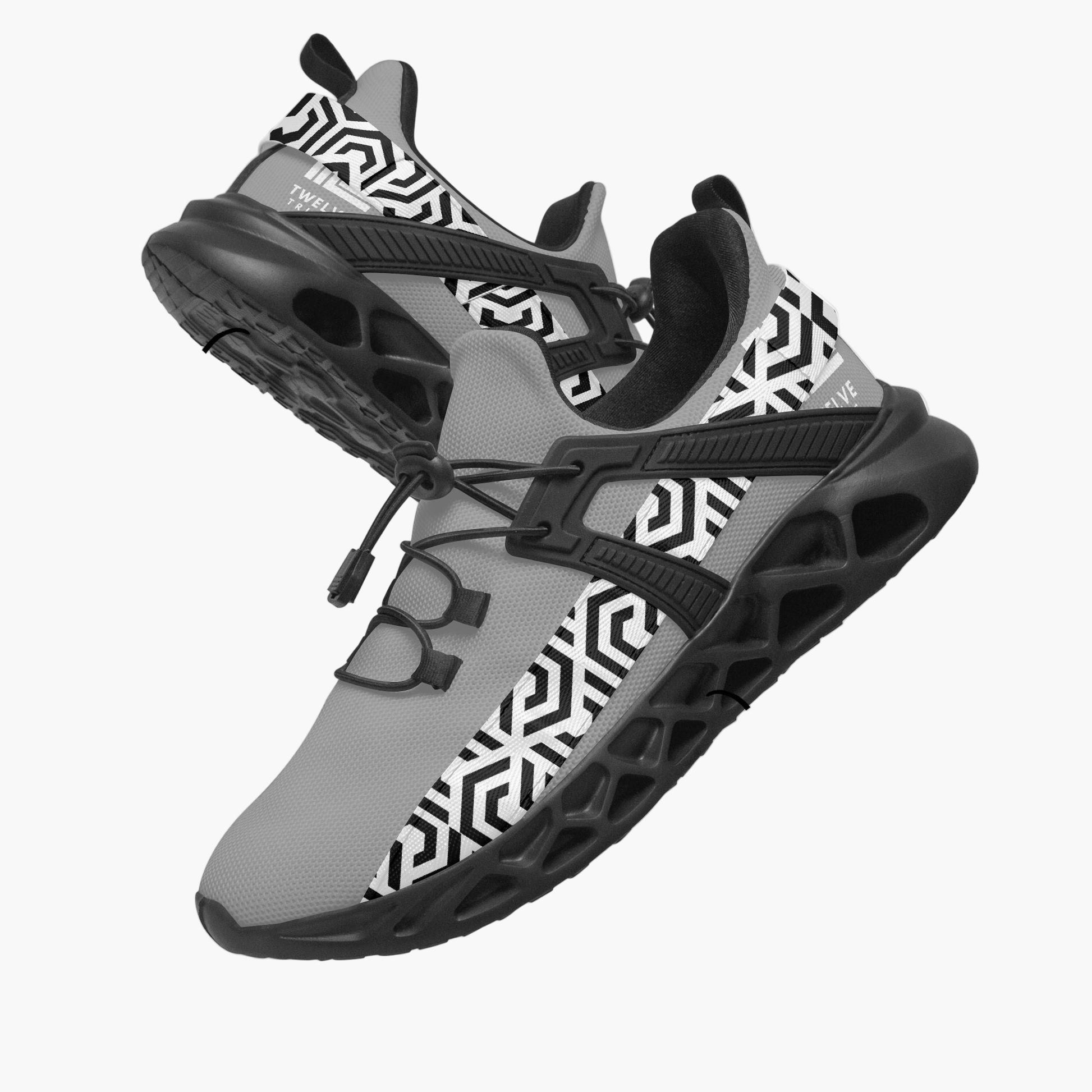 Gray and black athletic shoes with geometric pattern on a white background